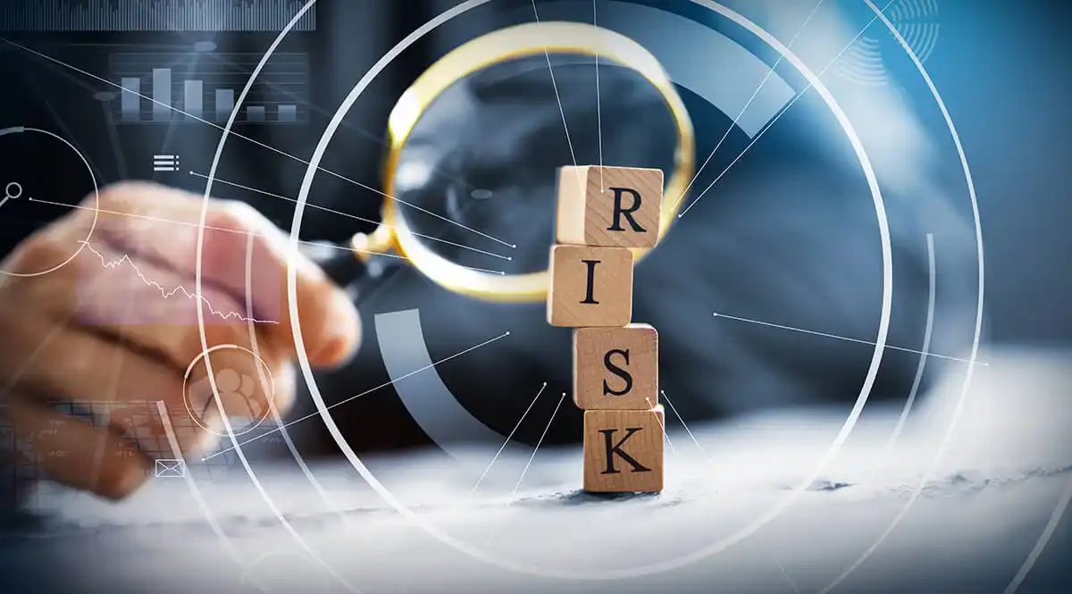 Wooden blocks spelling out 'RISK' under a magnifying glass, symbolizing the scrutiny of risk measurement methods in financial analysis.